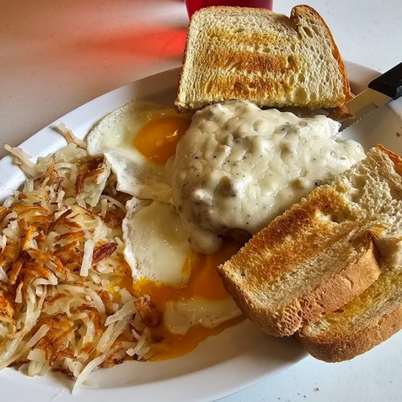 Hen House Cafe's breakfast plate with hash browns, fried eggs, biscuits and gravy, and toast.